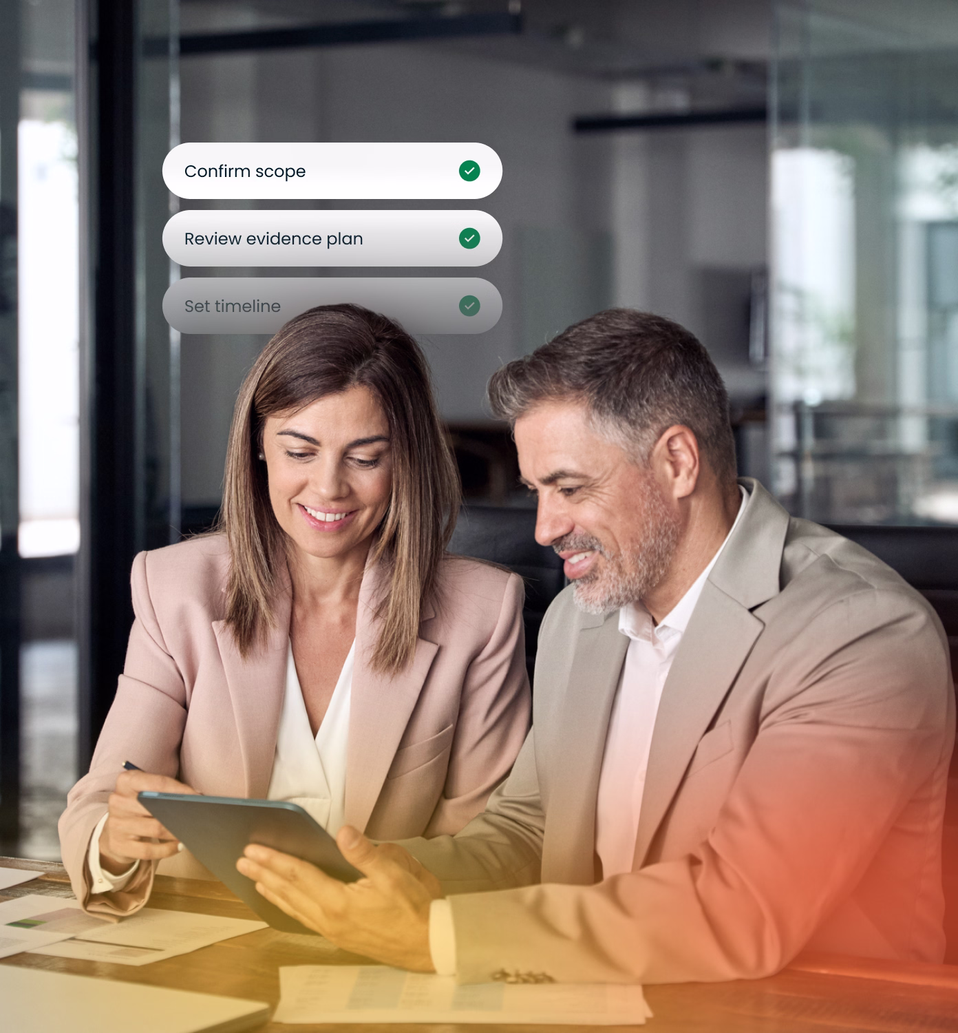Two business professionals, a woman and a man in beige blazers, sitting at a table reviewing documents and a tablet together in a modern office setting, with an overlay checklist showing completed tasks: Confirm scope, Review evidence plan, and Set timeline.