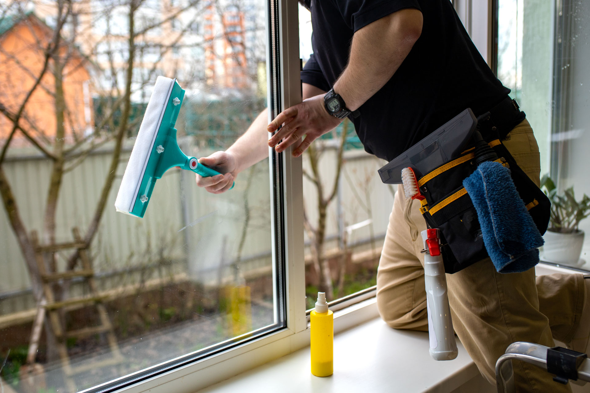 Professional window cleaning with tools and supplies.