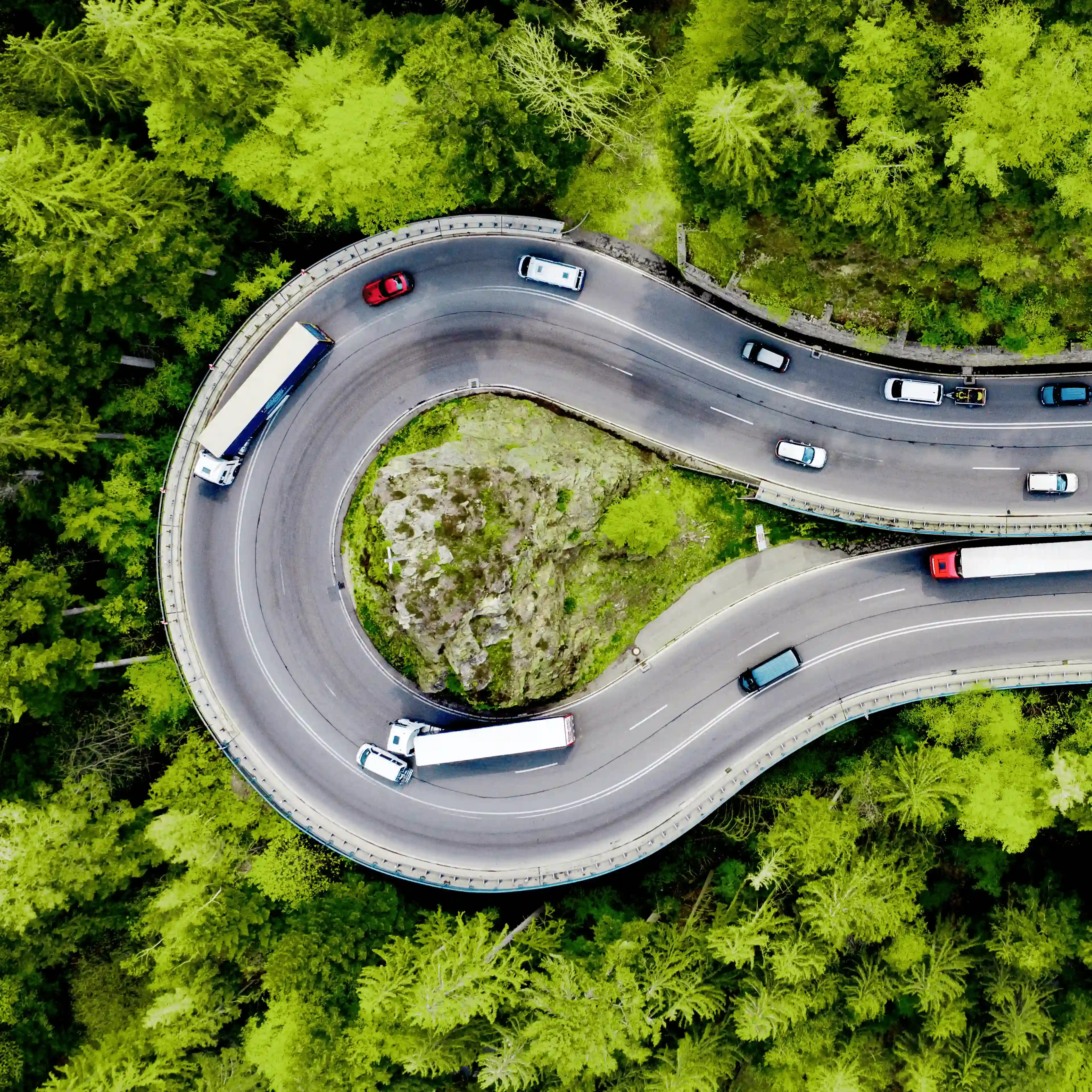 Luftaufnahme einer kurvigen Straße als Symbol für Orientierung und klare Wege in der Unfallschadenregulierung mit AdvoAuto.