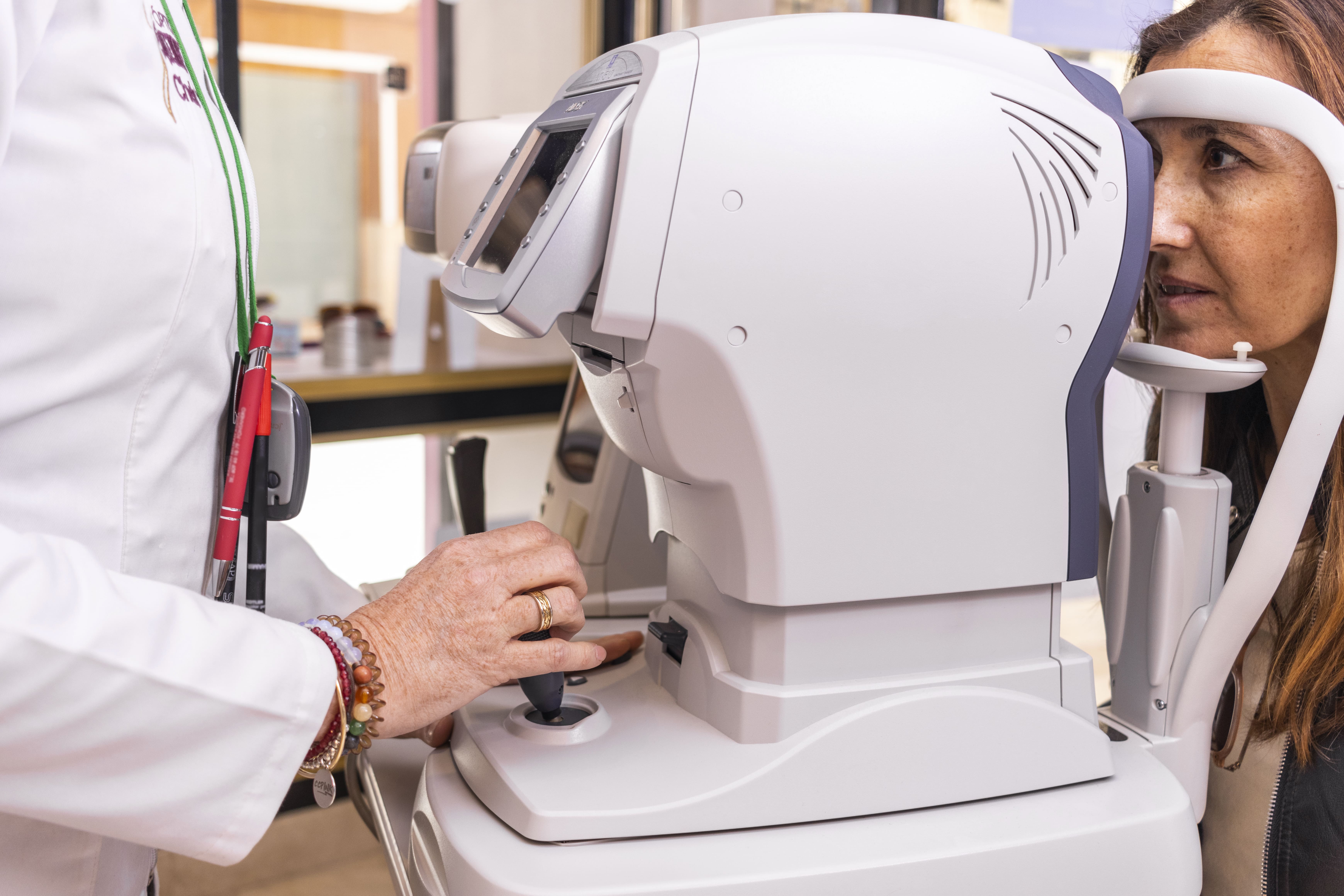 Patient undergoing eye exam with automated refraction machine at optometry clinic