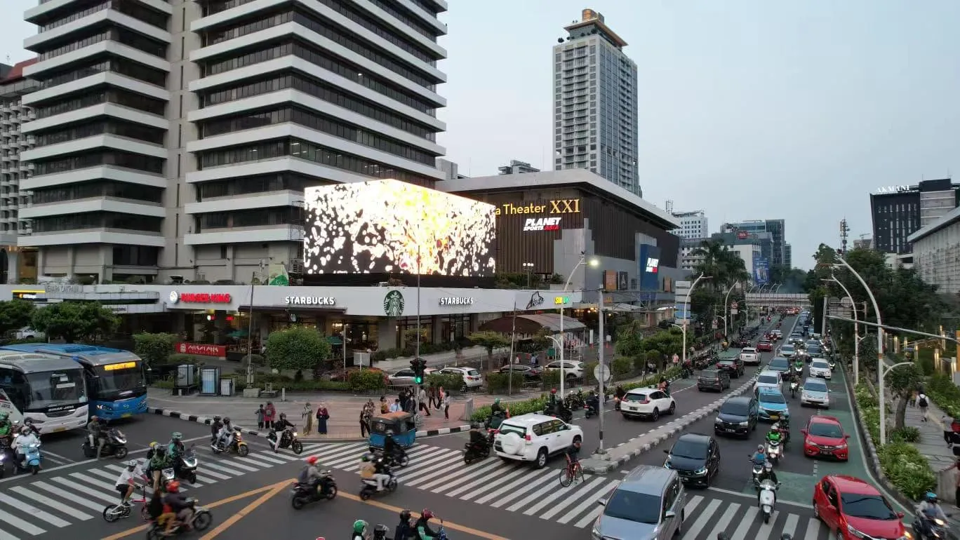 Outdoor transparent LED mesh screen integrated on a building facade in a city centre