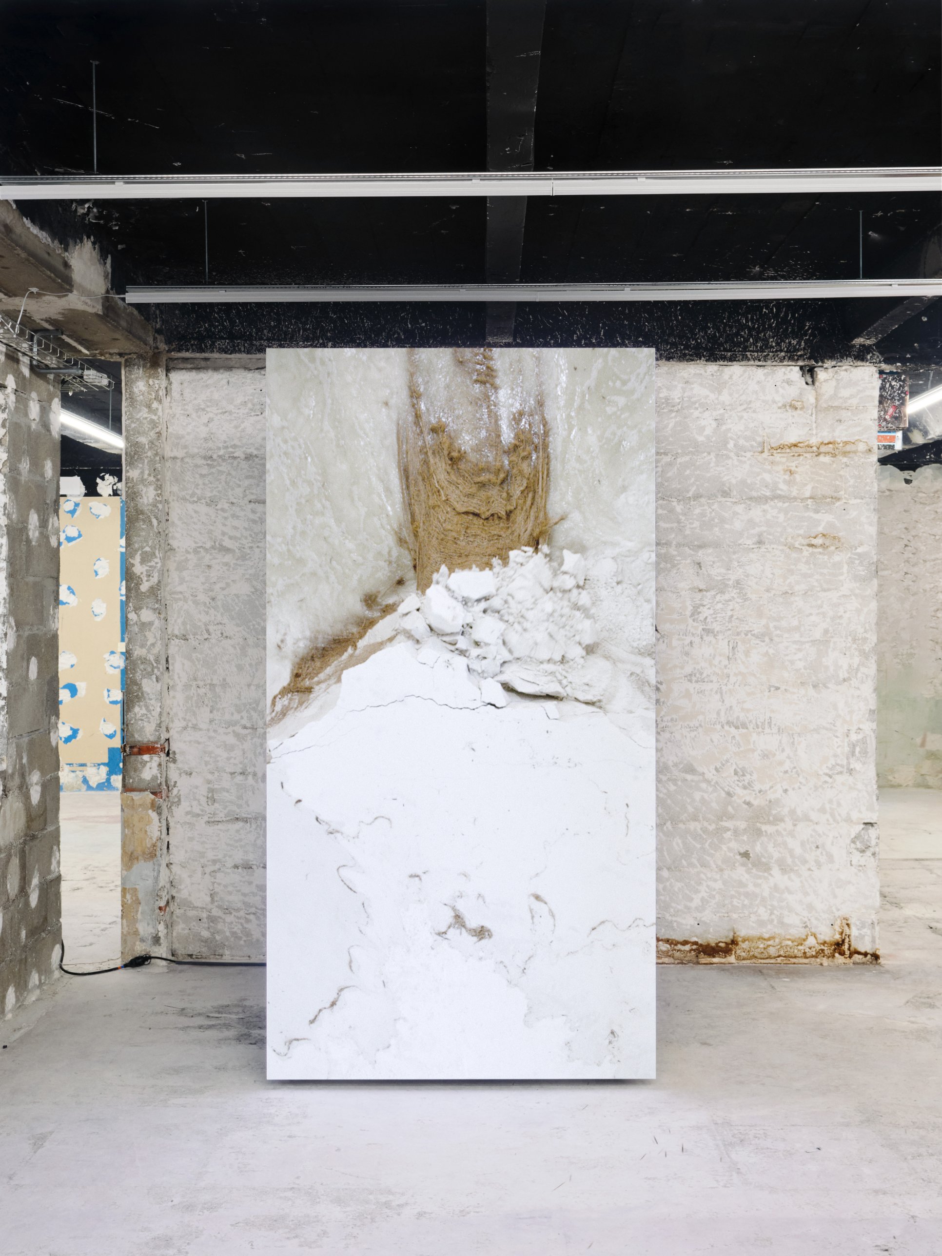Freestanding portrait LED screen showing marble-like textures and sand