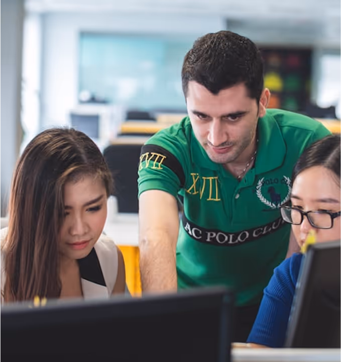 Team working together on a computer, modeling equity in AI and inclusive technology and social justice work.