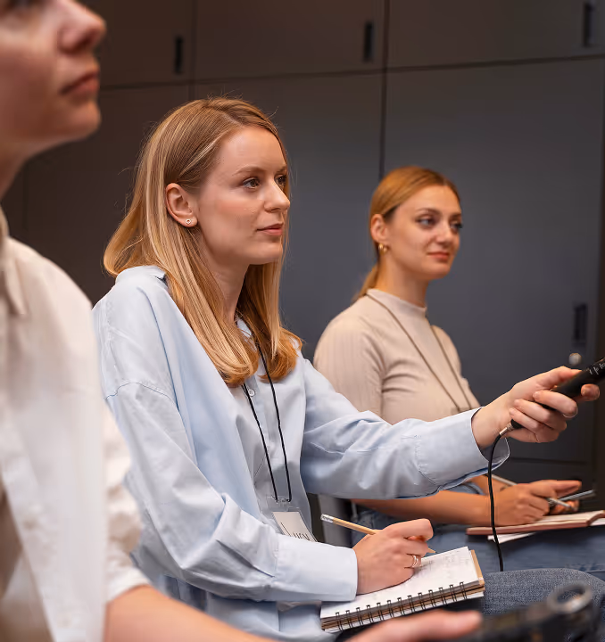 Woman participating in a seminar, reflecting emotion-centered design and youth digital experiences in action.