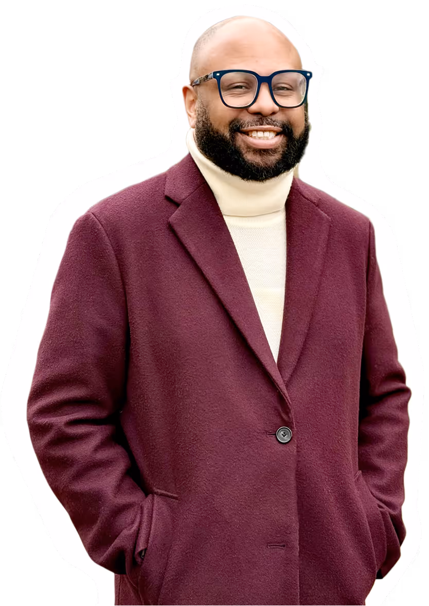 Desmond Upton Patton outdoors in burgundy coat, advancing trauma-informed research and digital empathy.