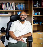 Desmond Upton Patton seated in office, shaping equity in AI and emotion-centered design for social justice.