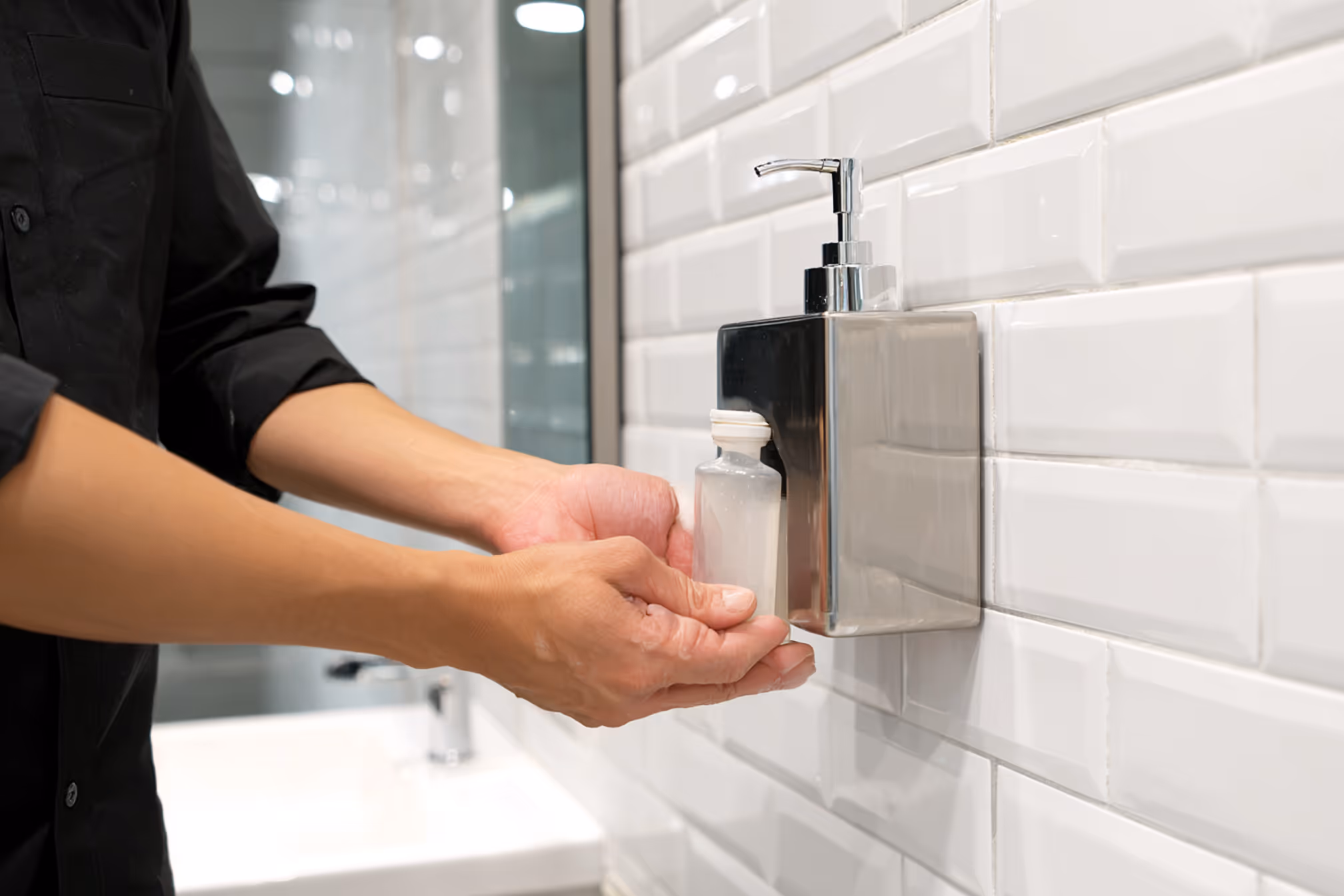 Nachfüllen eines Seifenspenders in Sanitäranlage – Karma Reinigungsservice sorgt für hygienische Reinigung & Materialservice in Waschräumen.