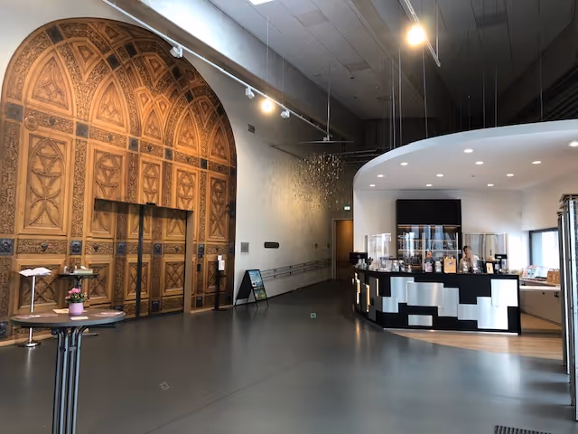 Blick in das Museumsfoyer, links ist die große Eingangstür zur Ausstellung zu sehen, rechts die Theke mit der Museumskasse.