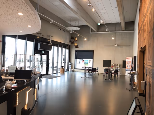 Blick in das Museumsfoyer, in dem Stühle stehen. Links ist die gläserne Eingangstür zum Museum zu sehen.