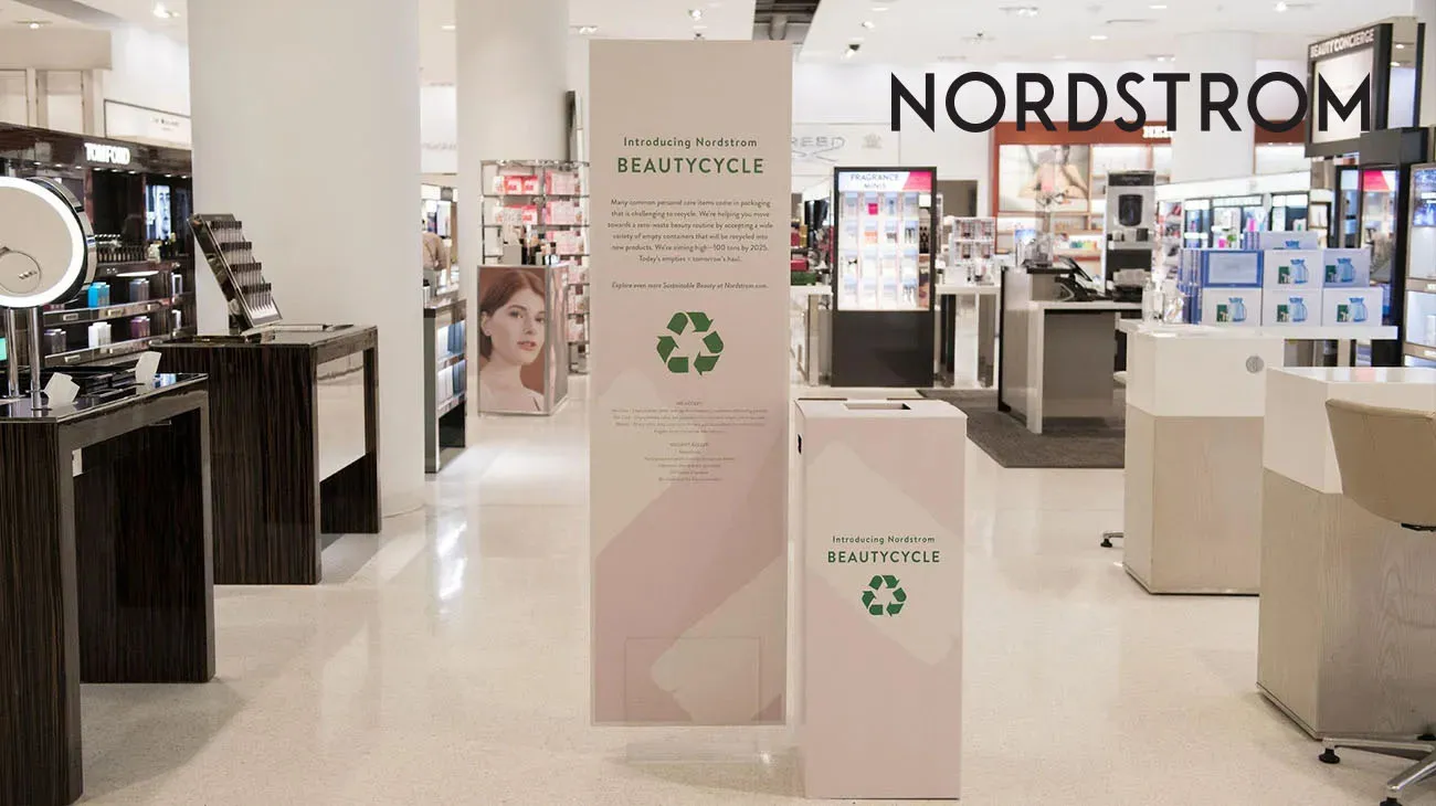 A customer service desk at Nordstrom with a sign advertising their "BEAUTYCYCLE" recycling program, powered by TerraCycle.