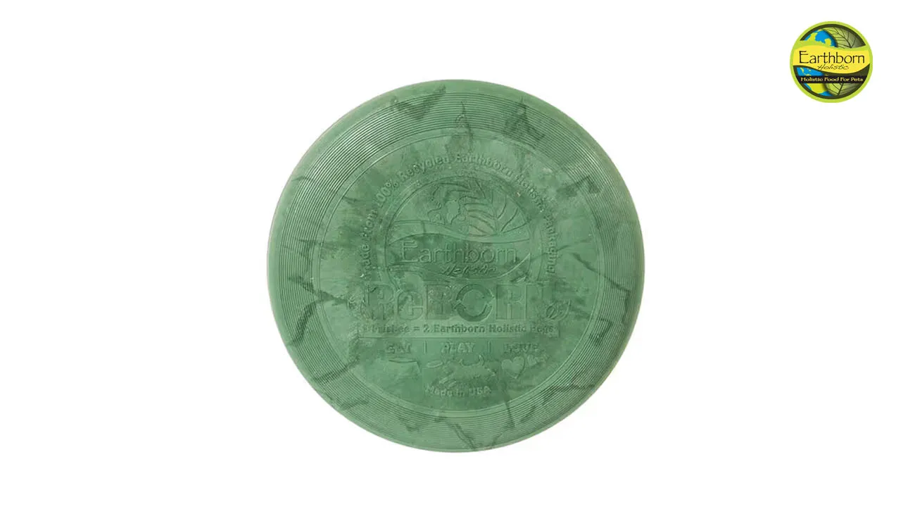 A dog sitting next to a bag of Earthborn Holistic pet food, highlighting the brand's recyclable packaging program with TerraCycle.