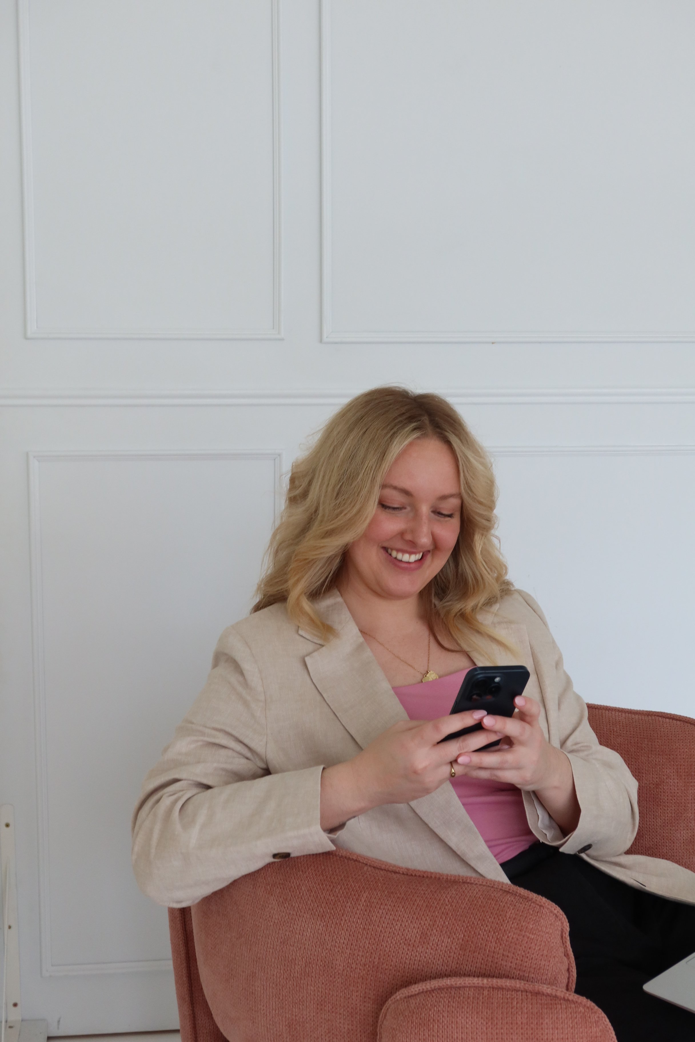 Hayleigh smiling while typing on her phone