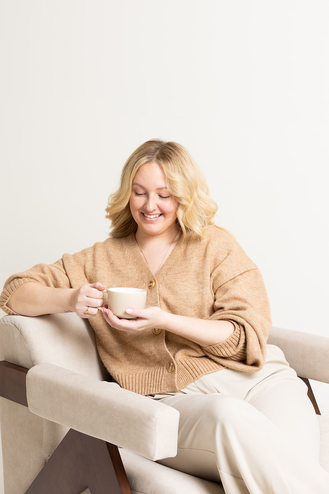 Hayleigh smiling while sitting on a couch and reading a newspaper