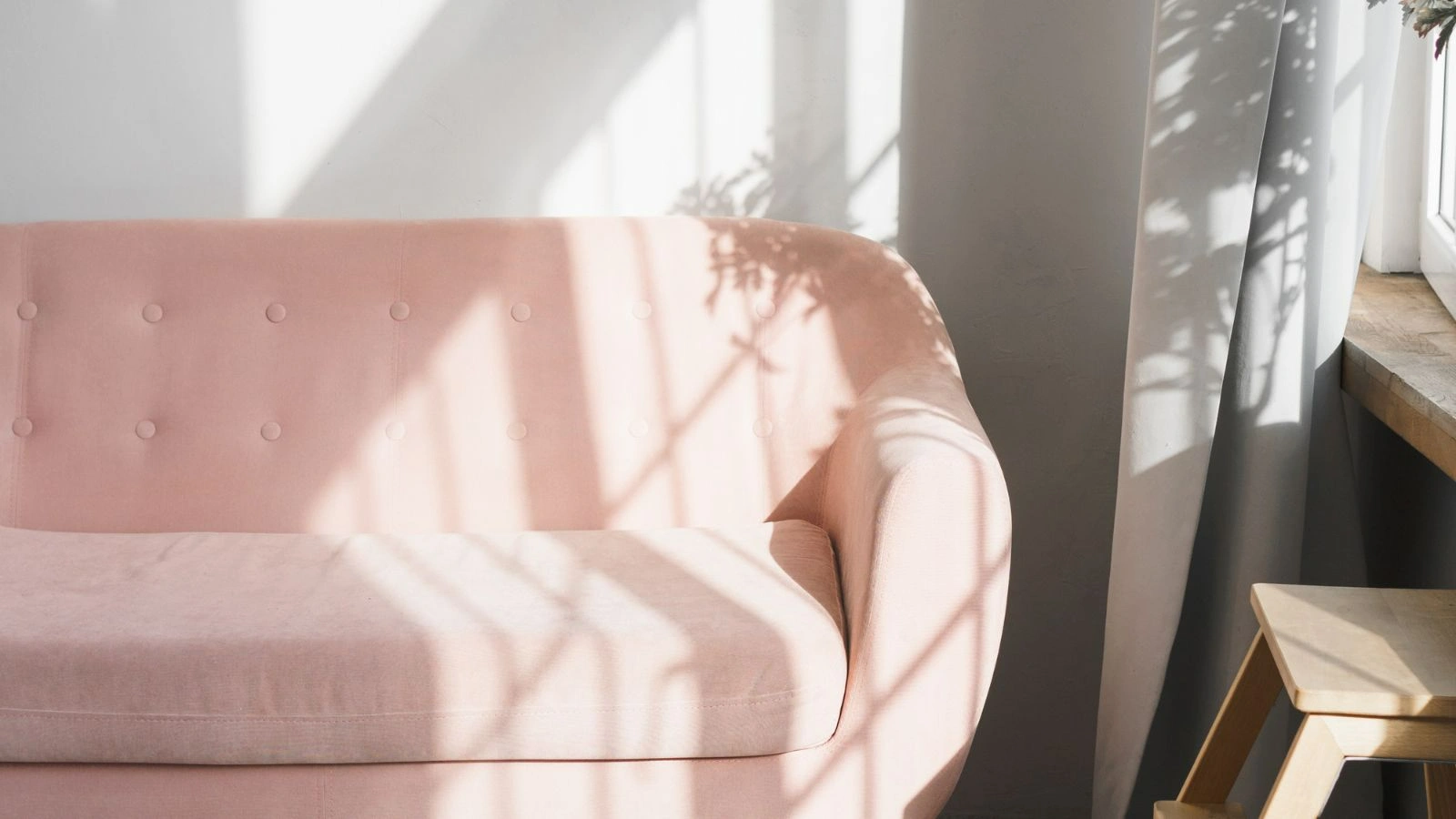 A pink couch on a naturally-lit room