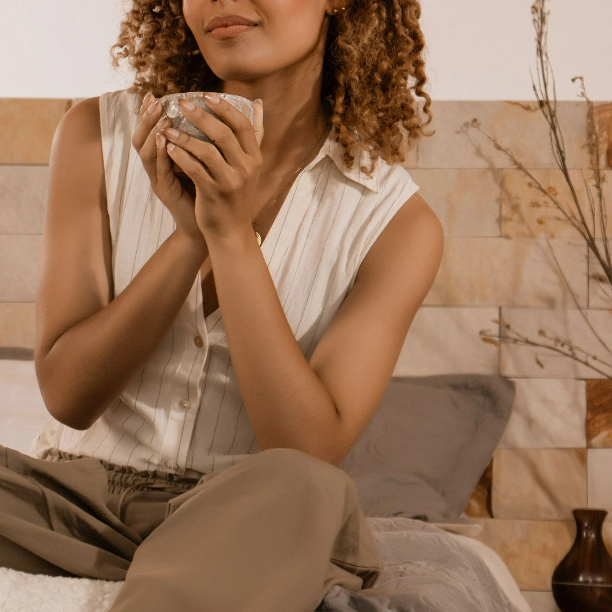 A business owner holding a cup of tea while having a break