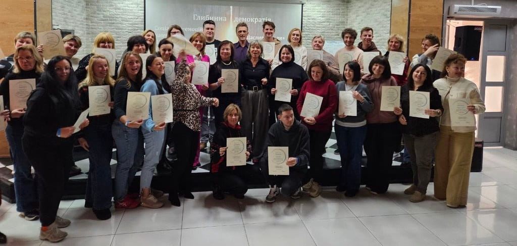 Teilnehmer mit Zertifikaten in der Hand in einer Ukrainischen Schule