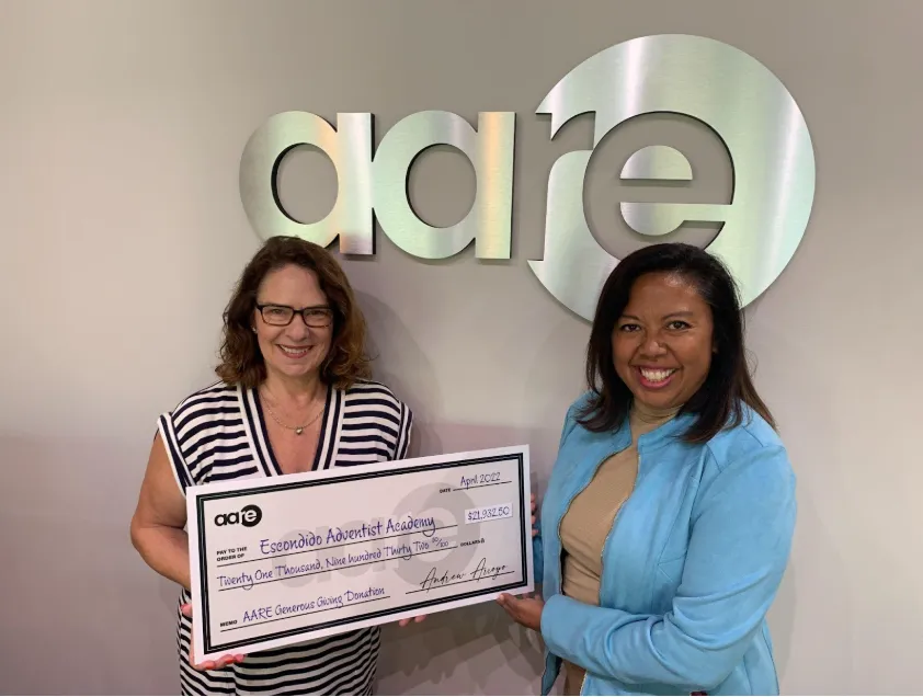Paolo and Galiano Tiramani, a father-son duo, stand in a warehouse under construction with metal framing and a "STAGING" sign in the background.