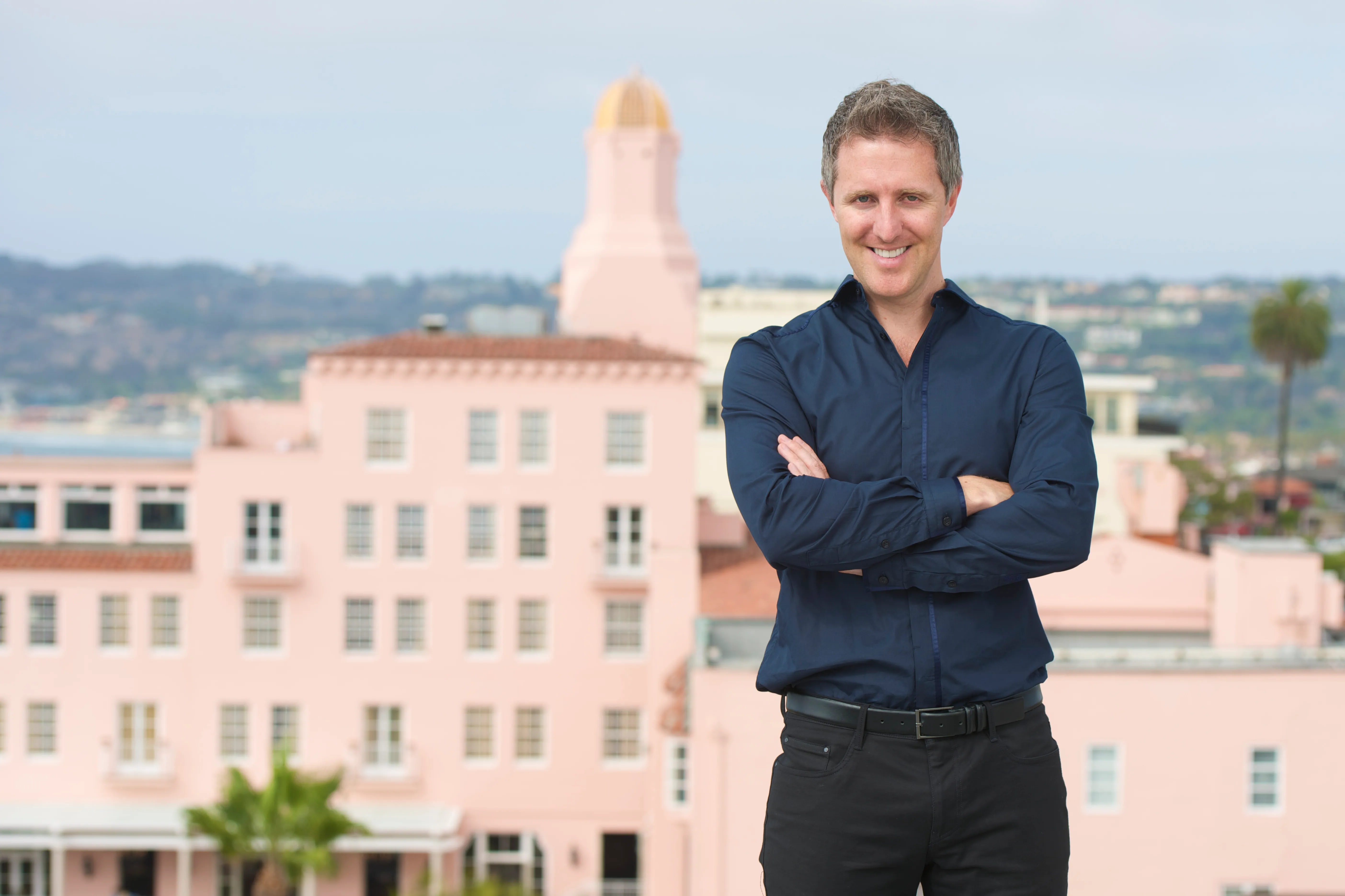 Paolo and Galiano Tiramani, a father-son duo, stand in a warehouse under construction with metal framing and a "STAGING" sign in the background.