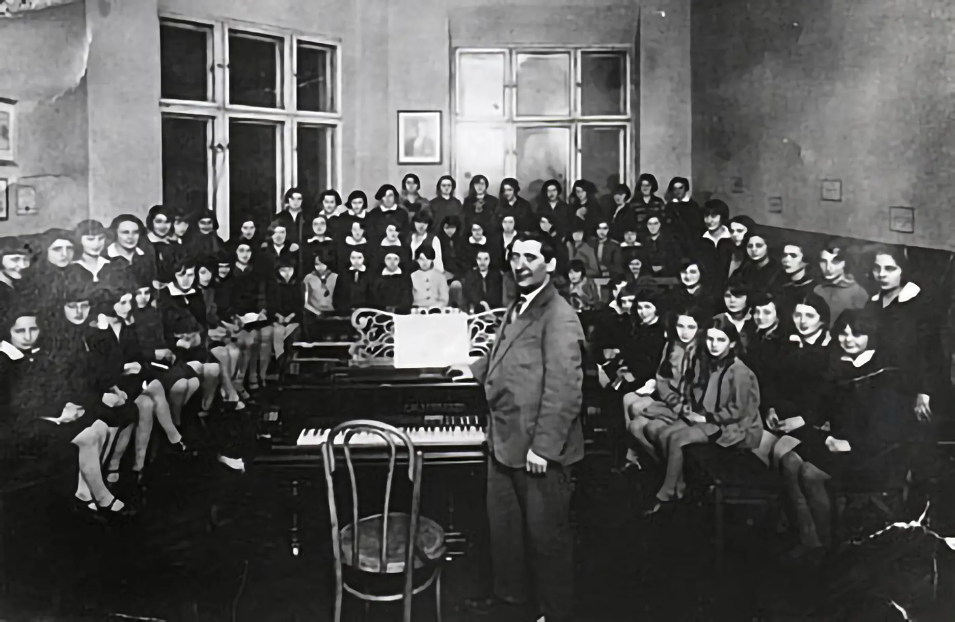 Professor Izrael Fajwiszyc, conductor and musician, posing with members of the Lodz choir of the Jewish high school for girls at 6 Paramowicza street. (c.1920)
