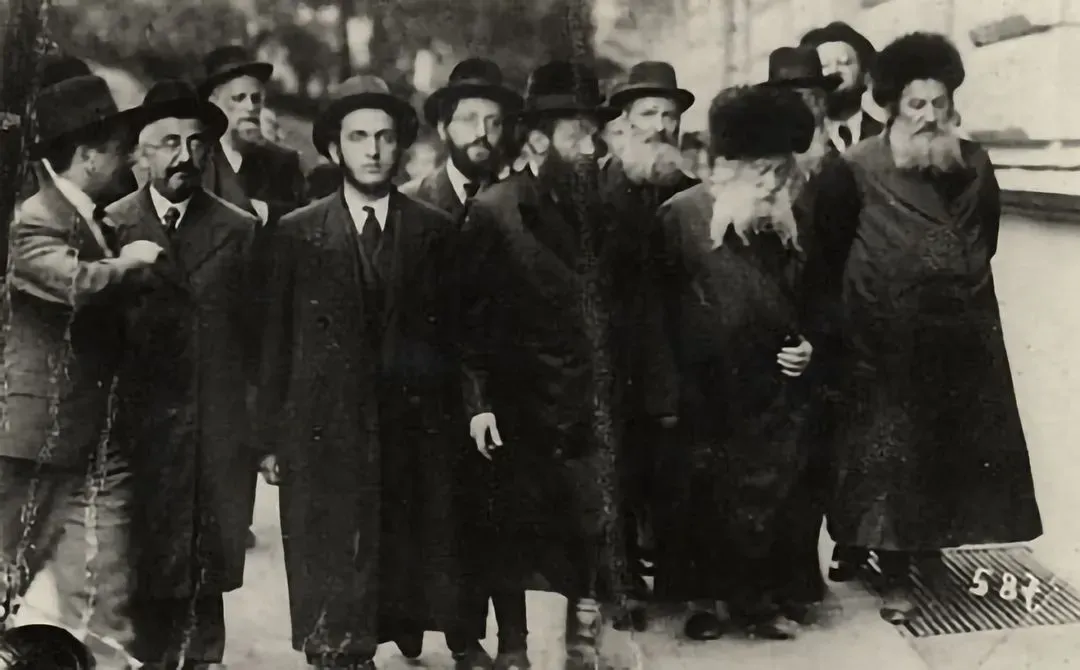 The Gerer Rebbe, Abraham Mordecai Alter (2nd from right), walking with a group of supporters.