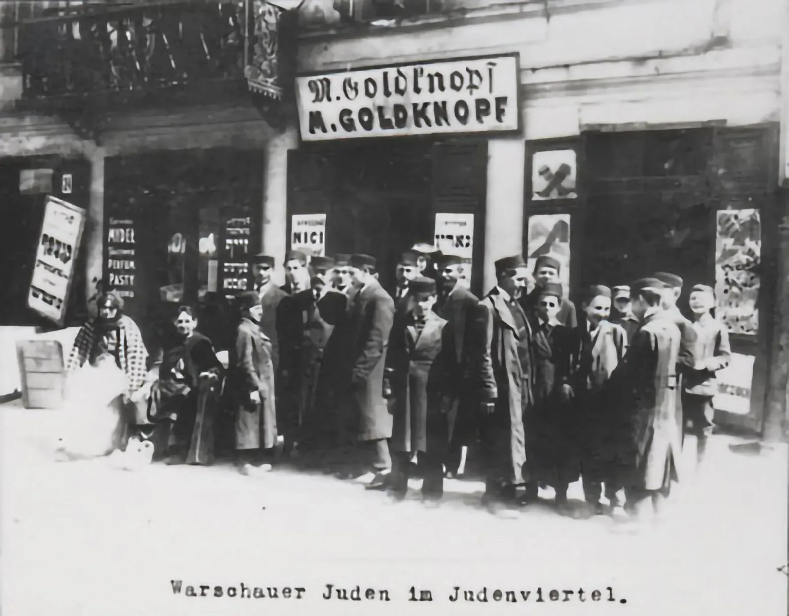 A group poses In front of M. Goldknopf's shop in the Jewish quarter: