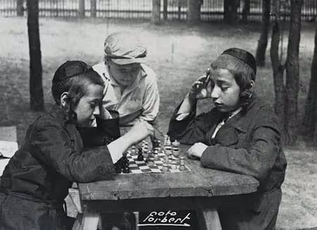 Boys playing chess at a summer camp "for children from distressed towns" operated by the Bialystok TOZ (Society for the Safeguarding of Health) in Jaroszowka, Poland (1930s).

