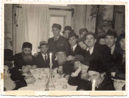 Lublin, 1942.  A wedding in the Lublin Ghetto: following the ceremony, guests sit together around the table.