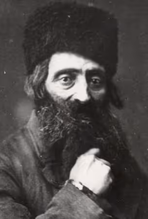 Portrait of a religious Jew, with the photographer's caption, "I am hanging onto the Talmud like a rabbi and like a tailor onto his mending." It is from a collection presented to Polish author Eliza Orzeszkowa in 1891 (Wolyn, Poland, circa 1880).