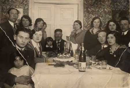 Portrait of a family gathering at the end of a meal (Zyrardow, Poland, date unknown).
