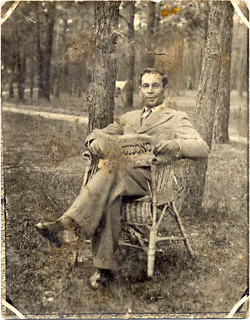 Zajczyk, a lumber merchant, outdoors reading a copy of the Yiddish newspaper "Moment" in Grodno, Belarus