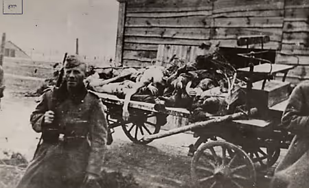 A German soldier stands in front of a wagon filled with the bodies of murdered Jews (Galicia, circa 1941.)