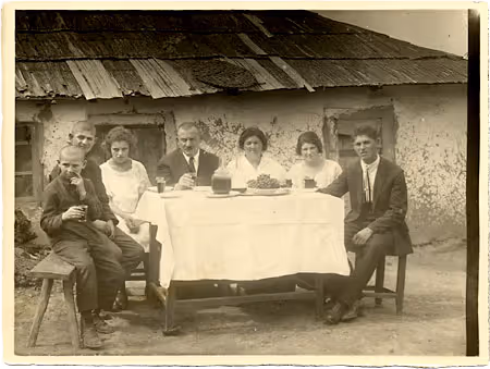 An agricultural colony family standing beside their table set for an outdoor Sabbath meal in Manzar, Bessarabia (now Moldova) 1920s.