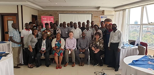 A group photo of Tom Ravenscroft sat alongside members of the Uganda National Examinations Board.