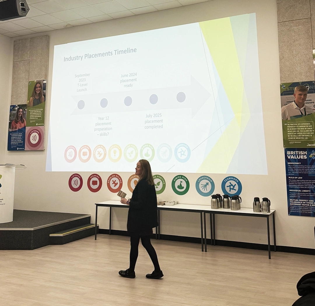 Nicola Graham giving a presentation at UTC warrington. Behind her are the eight essential skills icons. Her slideshow presentation shows a diagram of what an industry placement timeline looks like across the year.