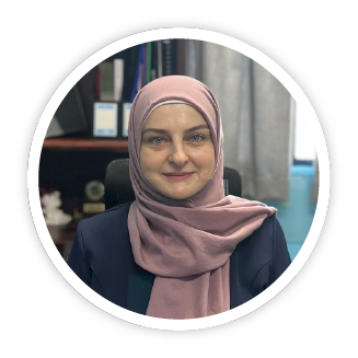 An image of Rana Hama, Skills Leader at Al Hadi. She is a middle eastern woman wearing a coral coloured hijab and a charcoal jacket. She has bright blue eyes and is is smiling warmly.