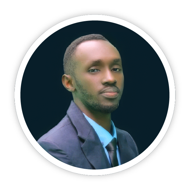 An image of Claude Nimbona from Action for Save Humanity in Emergency, Uganda. He is wearing a dark navy-blue suit with a sky blue shirt and is smiling coolly at the camera.