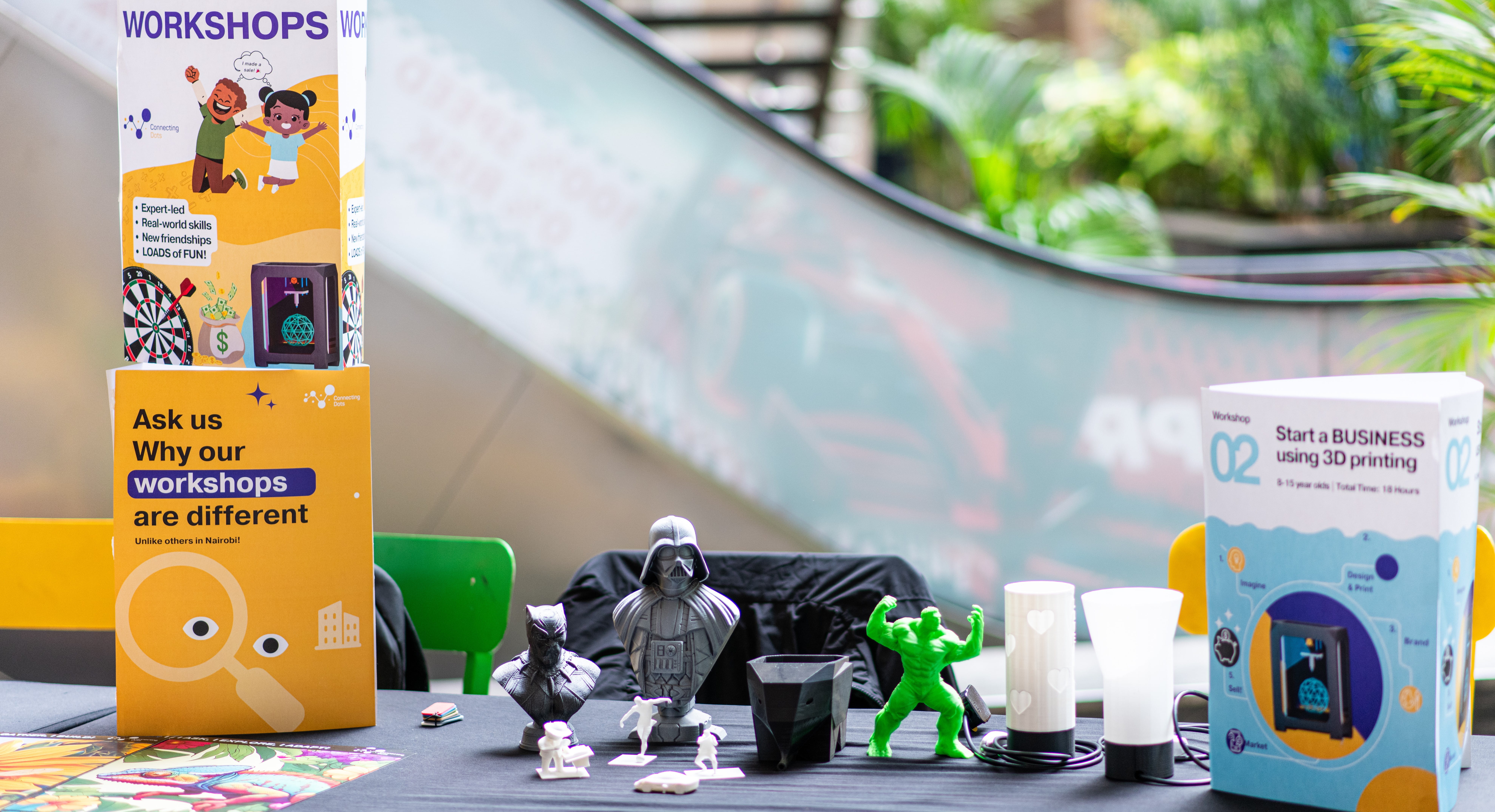 3D-printed figurines and workshop brochures on a display table