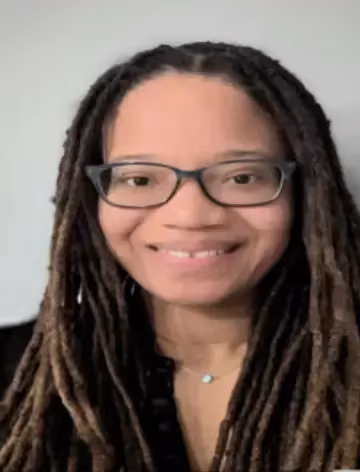 Professional headshot of staff member with glasses smiling