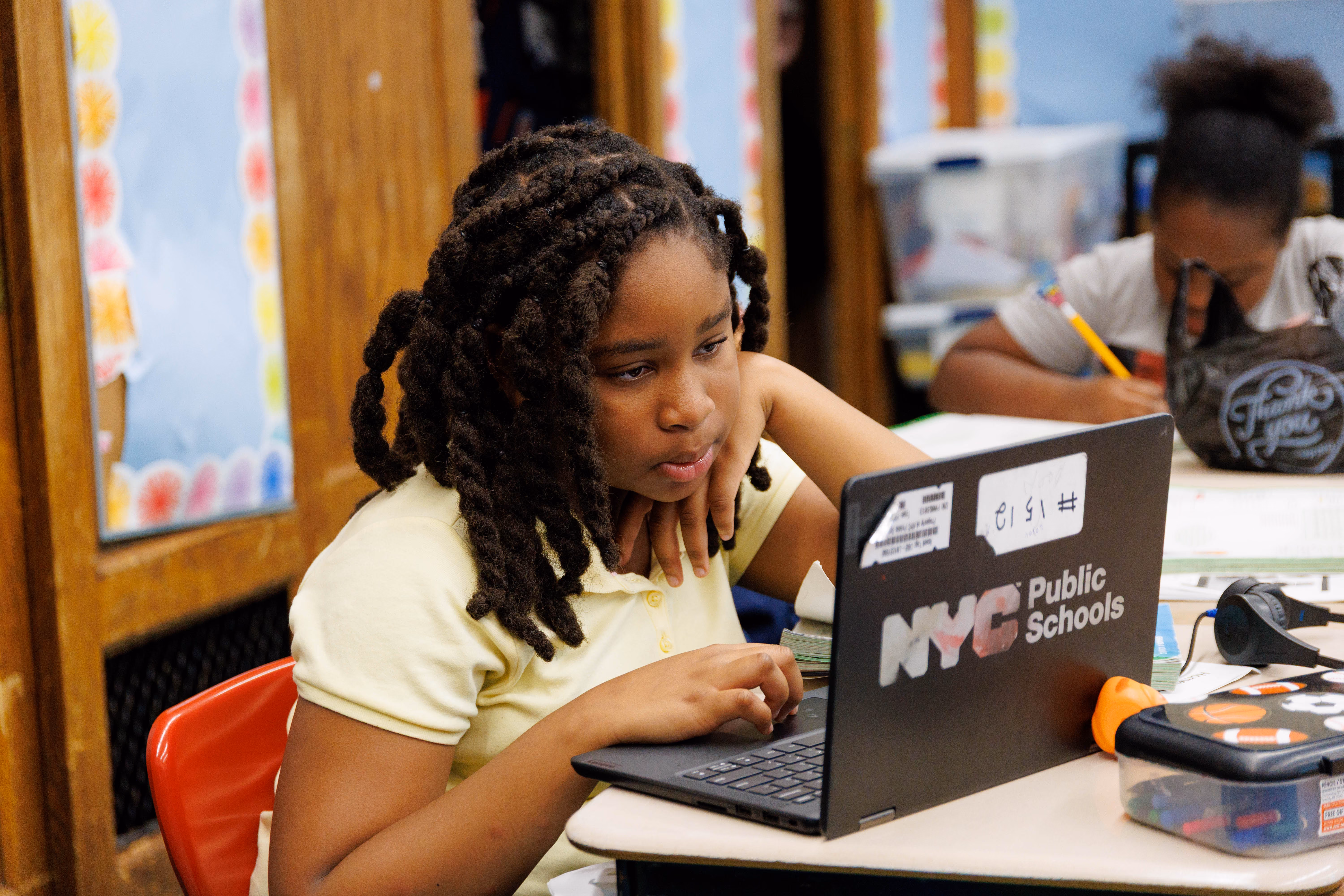 Student focused on an NYC Public Schools laptop in classroom