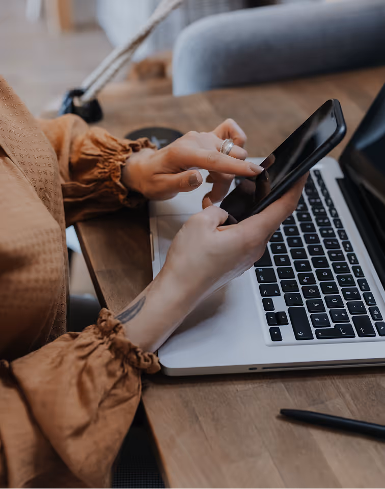 A woman sitting at a table using a laptop computer.