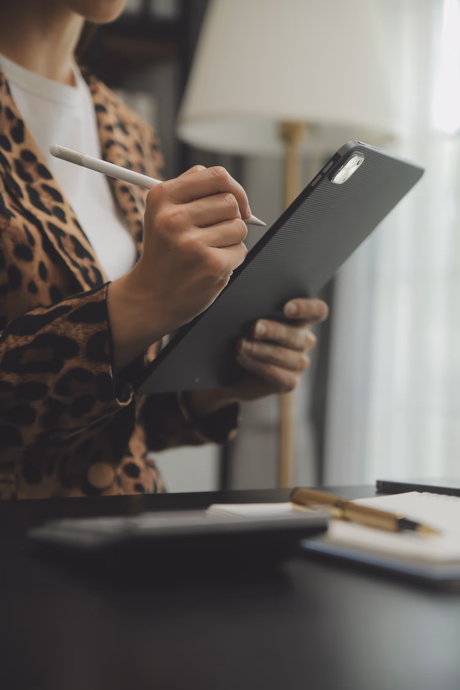 A woman holding a pen and writing on a clipboard.