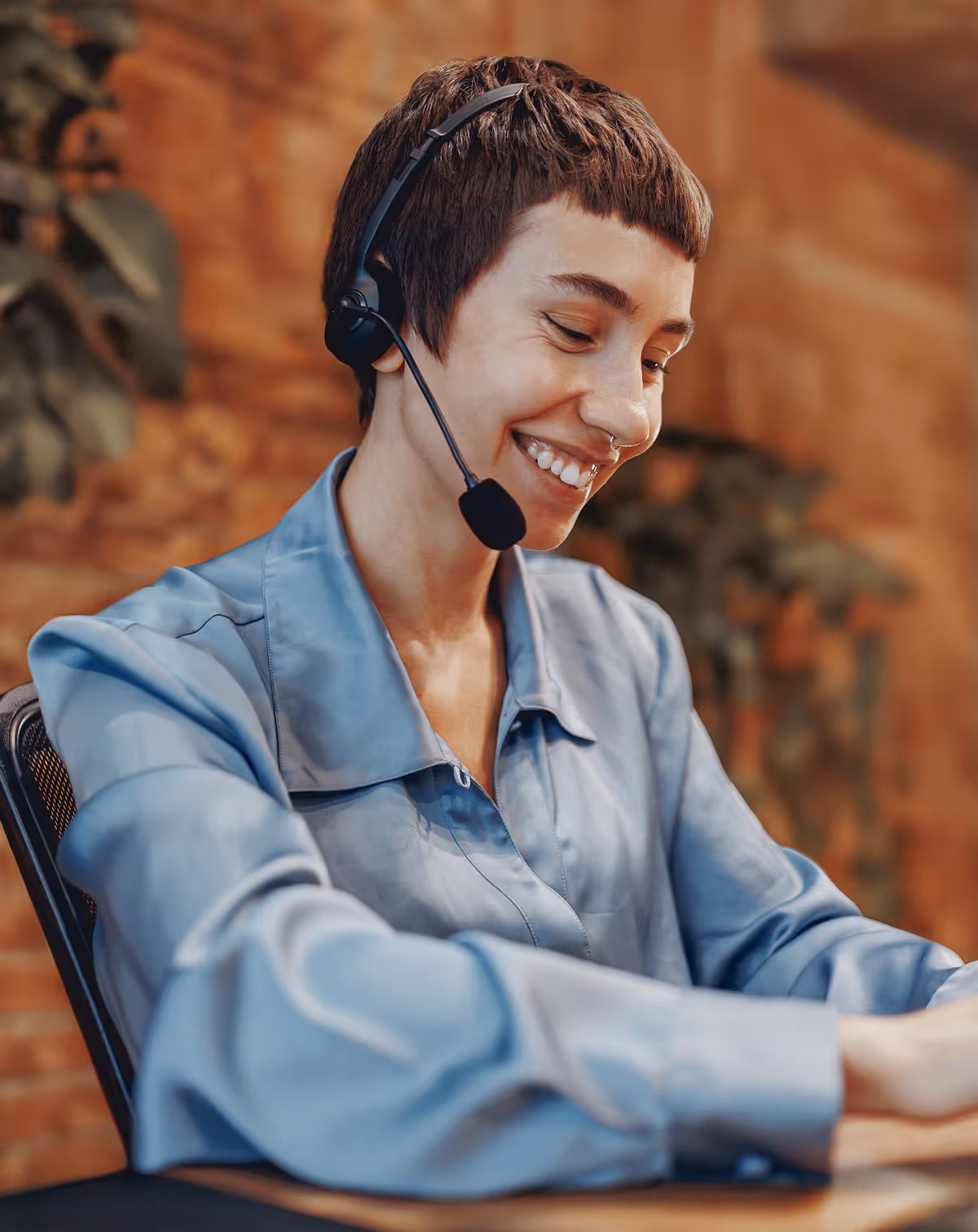 A woman sitting at a desk with a headset on.