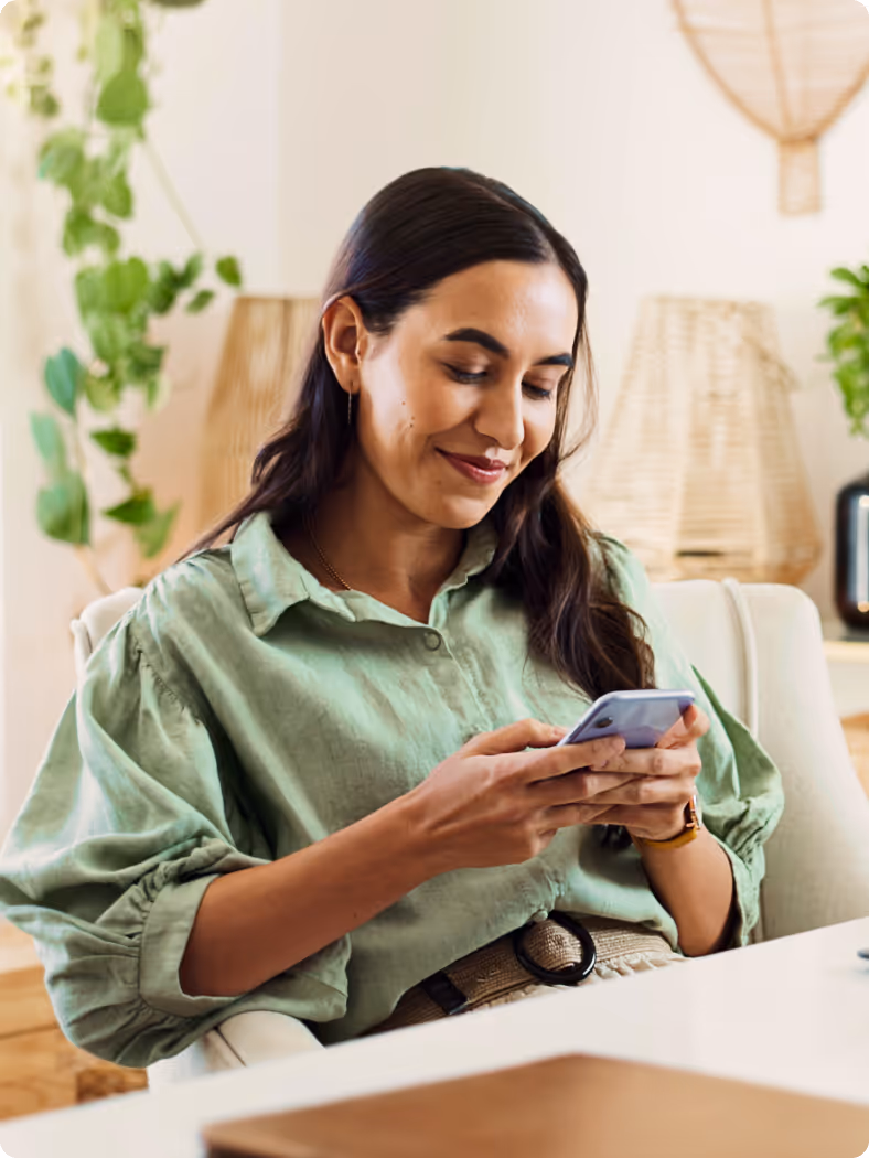 A woman sitting in a chair looking at her cell phone.