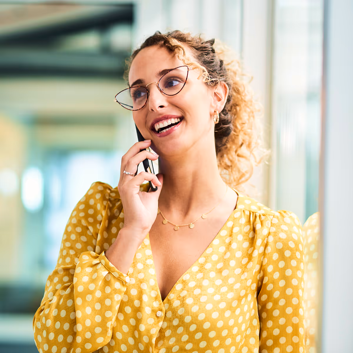A woman wearing glasses talking on a cell phone.