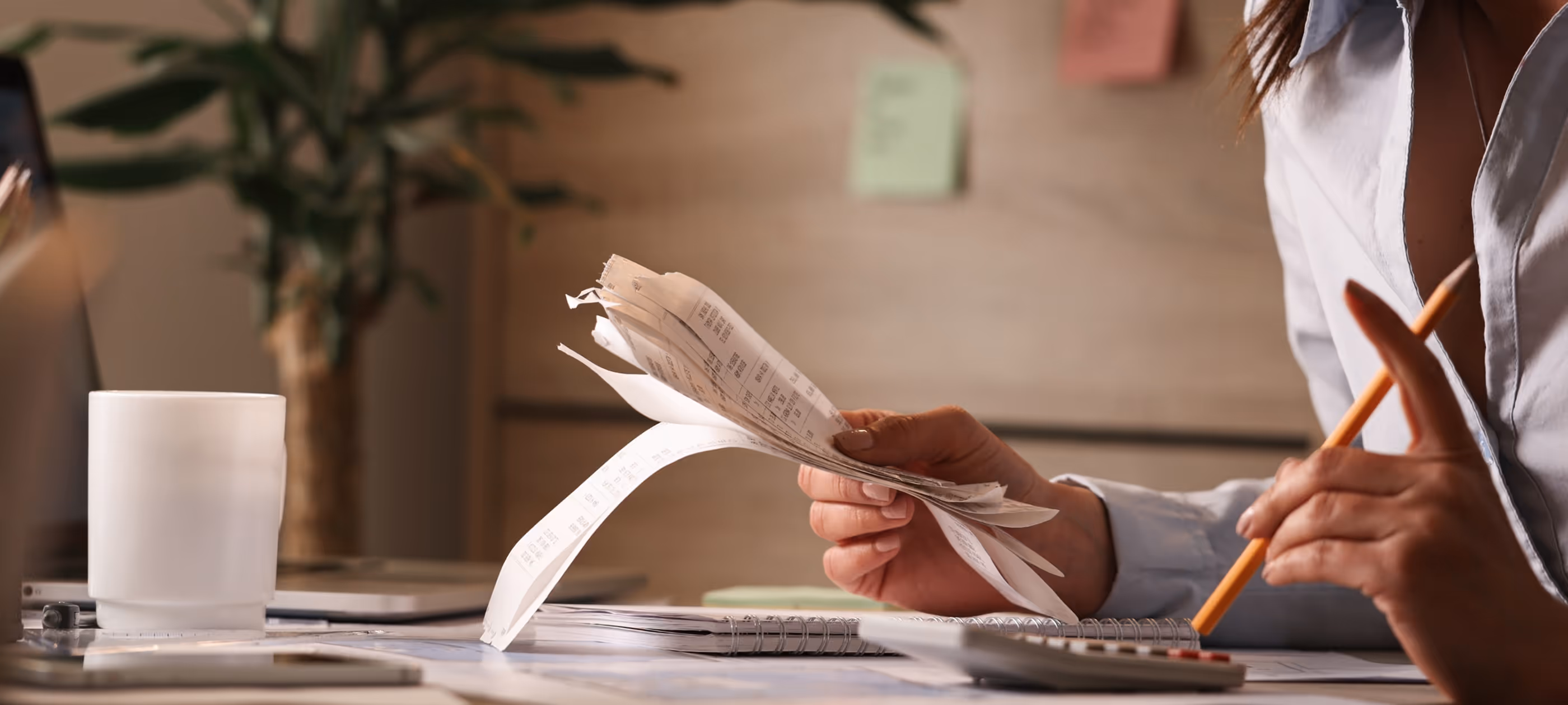 A woman sitting at a desk writing on a piece of paper.