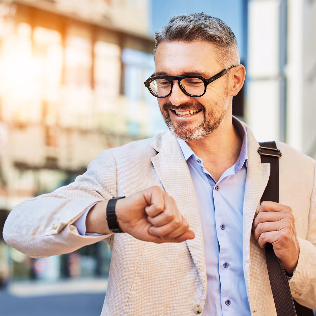 A man wearing glasses and a jacket pointing at something.
