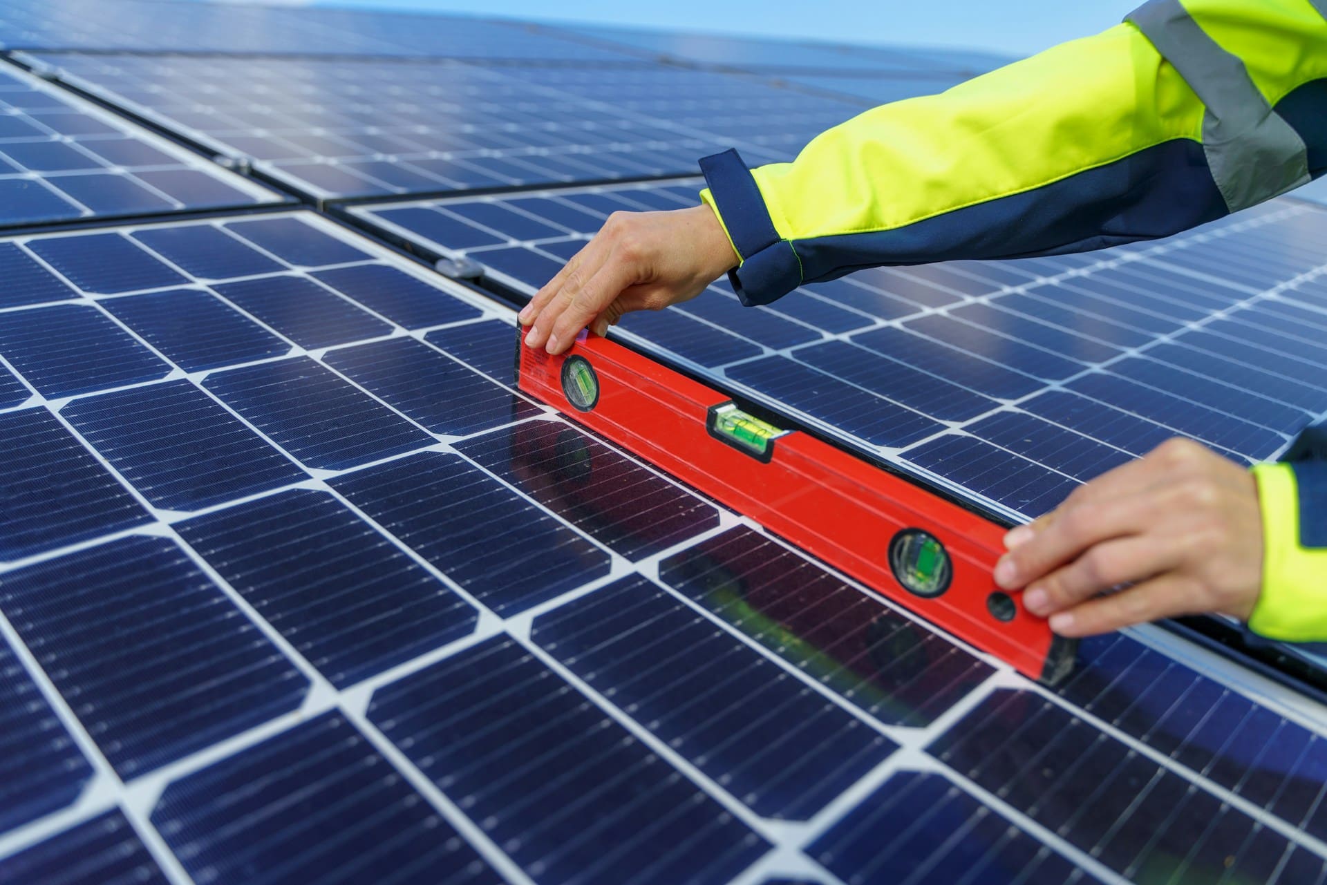 Un installateur pose un niveau sur des panneaux solaires pour en déterminer l'inclinaison