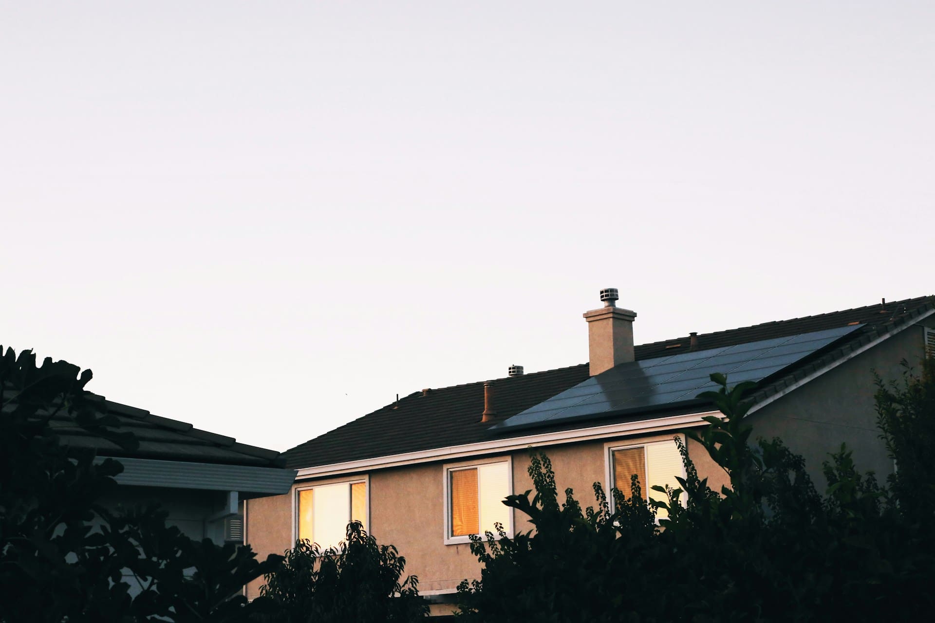 Maison dont le toit est surmonté d'un panneau solaire 
