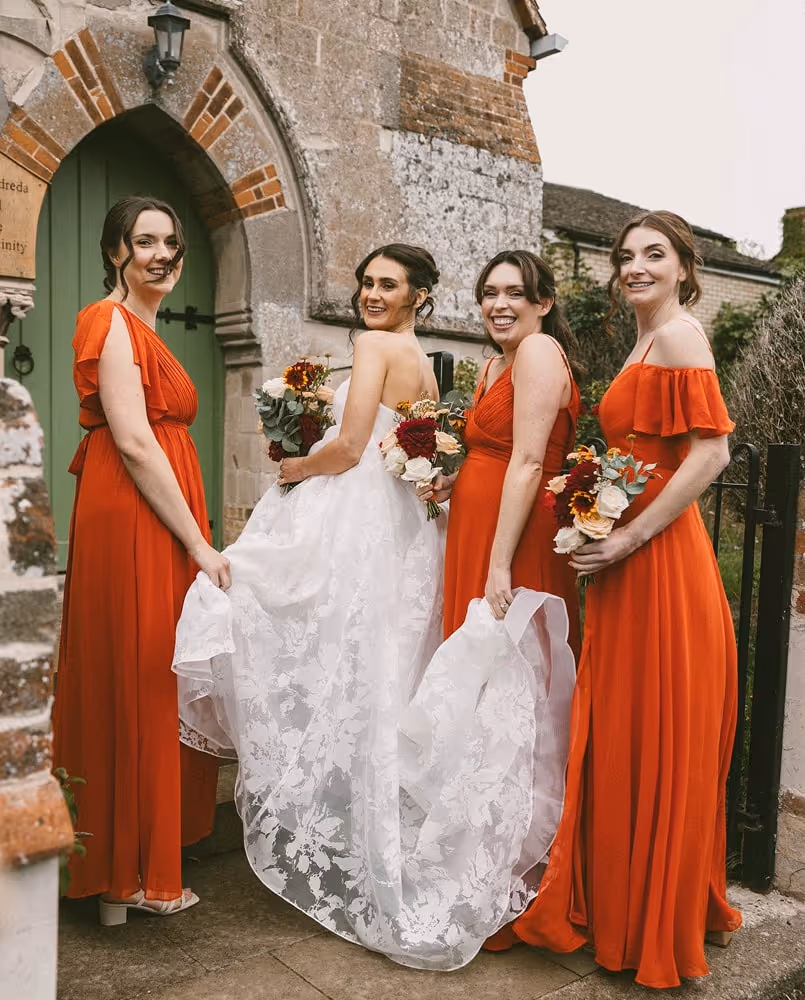 Bride and three bridesmaids in front of a church