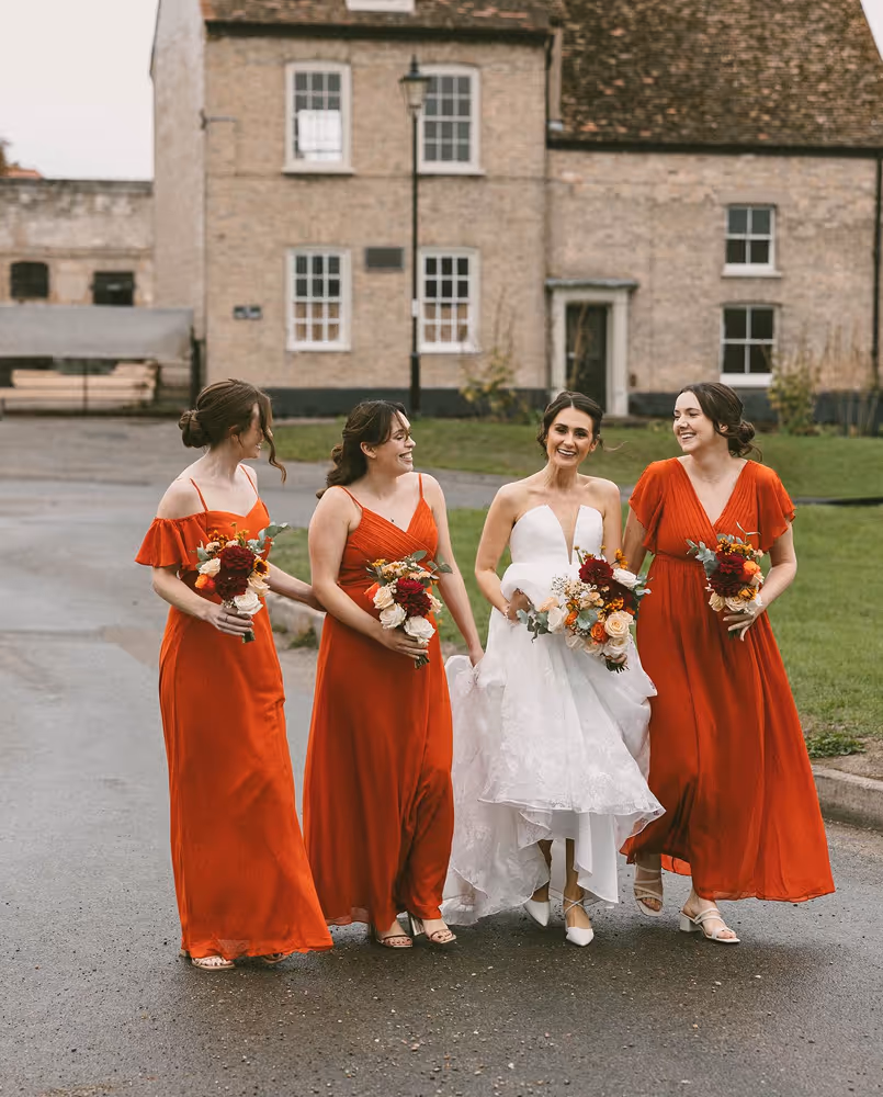 Bride and three bridesmaids walking on a road